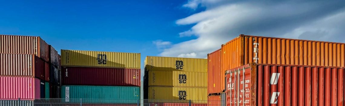 A truck is parked in front of a bunch of shipping containers. How to improve contracting in your business. Medium business. Construction Lawyer. AS2124-1992. AS2124