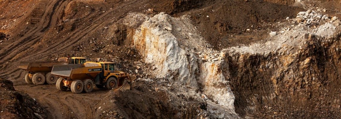 A large truck driving down a dirt road at a mining site. Latent Conditions