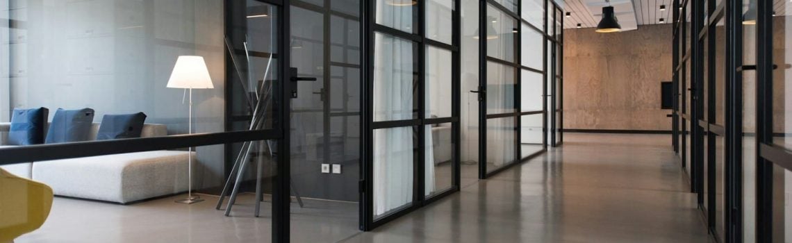 Office hallway between glass-panel doors. Commercial Lease Review